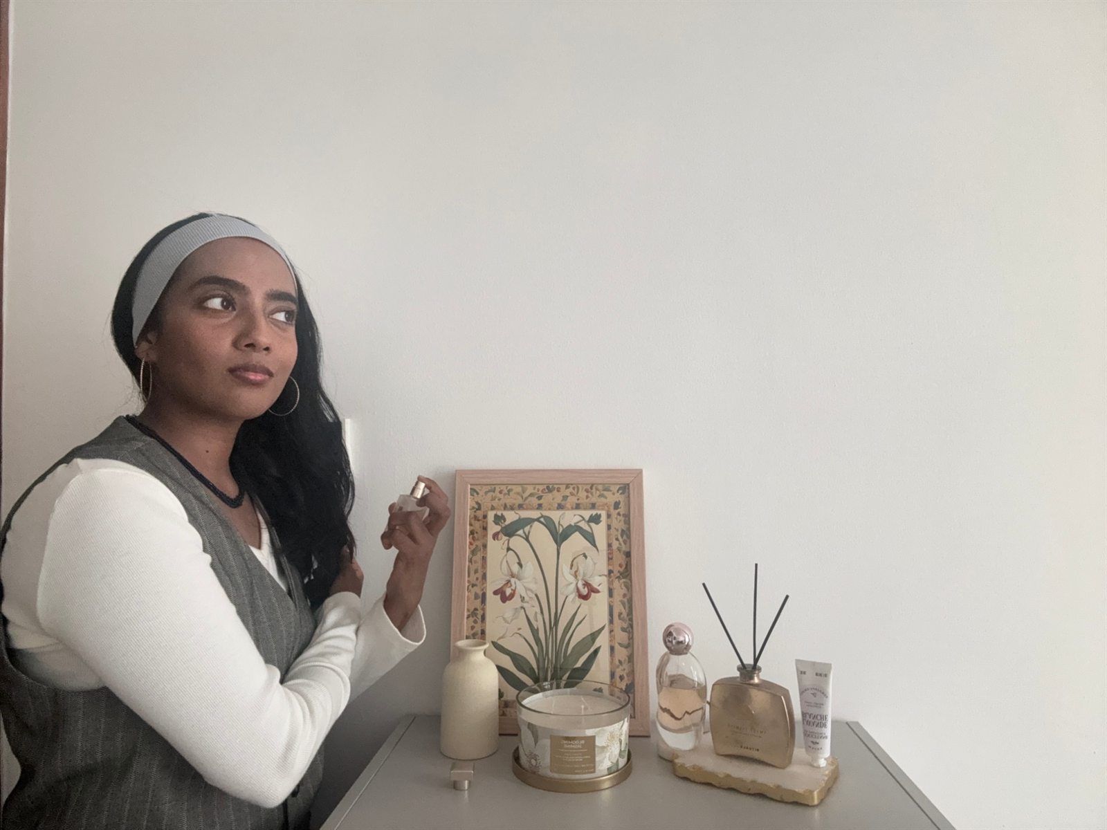 Abigail spraying a perfume beside a botanical print
